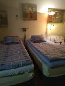 ポリにあるKoti Kiviniemiのベッドルーム(ベッド2台、ランプ付)