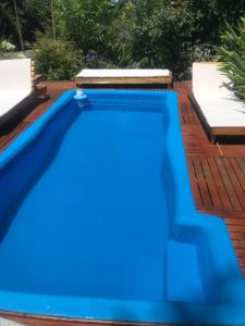 a blue swimming pool on a wooden deck at EL PARAISO DEL DESCANSO in Sierra de los Padres
