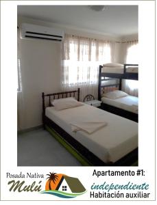 sypialnia z 2 łóżkami piętrowymi i oknem w obiekcie Posada Nativa Mulu w mieście San Andrés