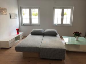 a large bed in a room with two windows at FeWo am Markt Wipperfürth in Wipperfürth