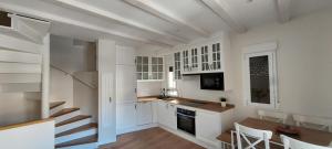 a kitchen with white cabinets and a table and a staircase at Casa la Fuentecilla in El Arenal