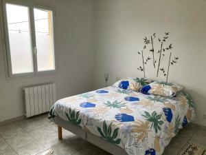 1 dormitorio con 1 cama con colcha de flores en LE 30, en Cognac