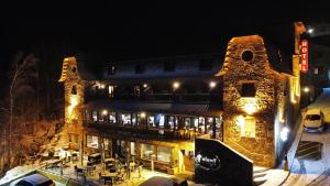 un gran edificio de piedra con luces encendidas por la noche en Hotel & SPA Niunit, en Ordino
