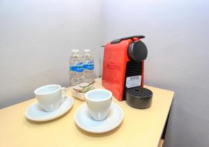 a coffee maker and two cups on a table at Casa Florencia Hotel Boutique in Guanajuato