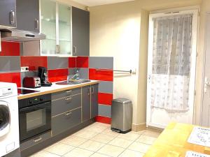 a small kitchen with red and gray walls at Petit Cocon cosy au cœur du village d'Allauch in Allauch