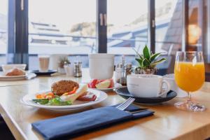 une table avec des plaques alimentaires et un verre de jus d'orange dans l'établissement m3Hotel, à Sankt Anton am Arlberg