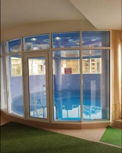 索契的住宿－Hotel BERGS，一间设有玻璃门的房间和一个游泳池