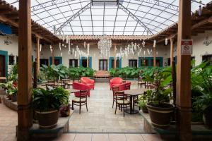a restaurant with red chairs and tables and plants at Gran Hotel El Encanto in San Cristóbal de Las Casas