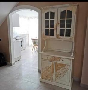 ジャルディーニ・ナクソスにあるResidence Villa candidaの白い大型キャビネット付きのキッチンが備わる客室です。