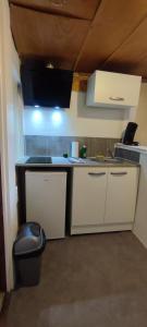 a kitchen with white cabinets and a sink and a stool at Studio hypercentre à 2 pas de la gare. Appart n°3 in Agen