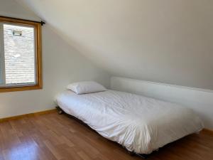 Cama en habitación con ventana en French Andes Apart Hostel, en Pucón