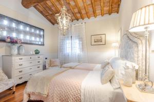 una camera con letto bianco e lampadario pendente di Pennecchio a Lucca