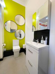 a bathroom with a white toilet and two mirrors at PHOENIX Apartments in Goole