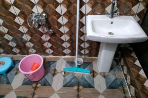 a bathroom with a sink and a bucket at Joshimath Camping & Cottage in Joshīmath