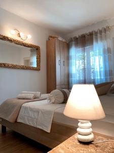 - une chambre avec un lit doté d'un miroir et d'une lampe dans l'établissement LoreMi apartment Pisak, à Pisak