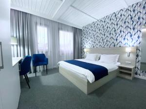 a hotel room with a bed and a desk and chairs at Willa Lazur ADULTS ONLY in Międzyzdroje