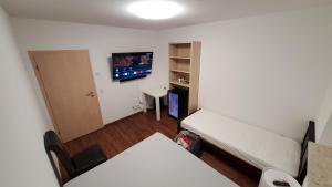 Habitación con cama y TV de pantalla plana. en Ferienwohnungen Im Grund 22, 22a, 22c, 22d Birkenstein, en Hoppegarten