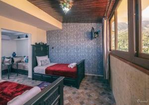 um quarto com uma cama, um sofá e uma janela em HOTEL PEDRO em Chefchaouen