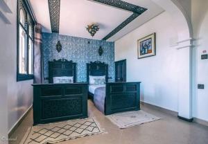 una camera da letto con letto e pareti bianche e blu di HOTEL PEDRO a Chefchaouen