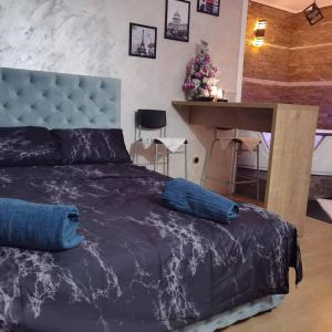 um quarto com uma cama azul e uma mesa em President spa apartman Arandjelovac em Arandjelovac