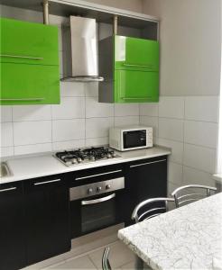 - une cuisine avec des placards verts et une cuisinière four supérieur dans l'établissement 2х кімнатна квартира у Львові поряд з залізничним вокзалом, à Lviv