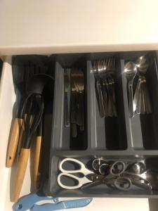 a drawer with scissors and utensils in it at Love Chalet in Nancray