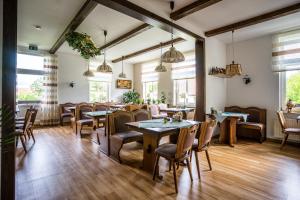 a restaurant with tables and chairs and windows at Pension Schweizer Hof in Wernigerode