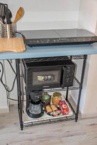 een magnetron op een plank onder een tafel bij Cozy Dante's Apartment in Florence +9 foto's