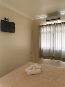 Un dormitorio con una cama con una toalla. en Apartamentos 800 metros do Mar - Residencial Vieira, en Florianópolis