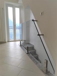 a staircase in a white room with a large window at Domus Graziana in Oliveto Lario
