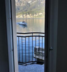 una habitación con vistas a un barco en el agua en Domus Graziana, en Oliveto Lario