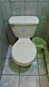 a white toilet in a bathroom with a trash can at AC Room 4 Persons Hospedaje Don Wilfredo in San Juan del Sur +2 photos