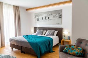 a bedroom with a bed with a blue blanket on it at Meublè La Betulla in Chiesa in Valmalenco