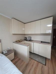a kitchen with white cabinets and a bed in a room at Apartment 607 in ORBI PALACE in Bakuriani