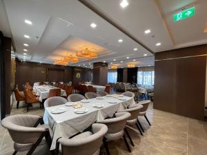 una sala da pranzo con un lungo tavolo e sedie di Deluxe Resort and SPA a Shkodër