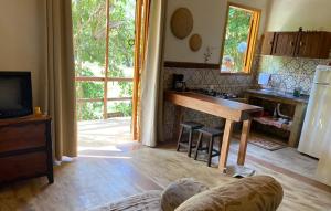 a kitchen with a table and a desk in a room at Chalé Filhos da Terra in São Francisco Xavier