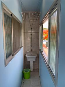 baño con lavabo y aseo y 2 ventanas en Apartamentos 800 metros do Mar - Residencial Vieira, en Florianópolis