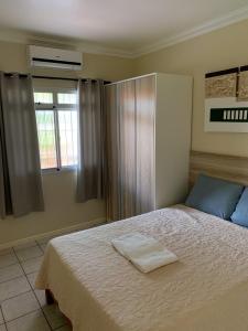 Un dormitorio con una cama con una toalla. en Apartamentos 800 metros do Mar - Residencial Vieira, en Florianópolis