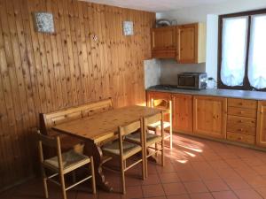 a wooden kitchen with a wooden table and chairs at Casa Dolonne - A un passo dallo sci in Courmayeur