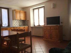 eine Küche mit einem Tisch und einem Flachbild-TV in der Unterkunft Casa Dolonne - A un passo dallo sci in Courmayeur
