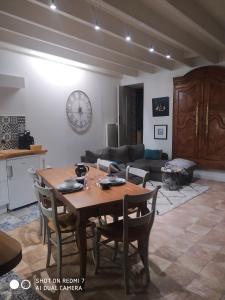 een woonkamer met een houten tafel en stoelen bij Le Cati Mini in Cancale