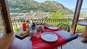 a table with a red table cloth on a table with a view at Timo's Guest House in Berat