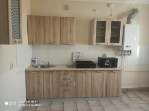 a kitchen with wooden cabinets and a sink at Apartments Domovik Parkaniya, 2A in Mukacheve
