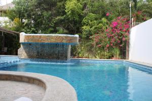 a swimming pool with a water fountain in a yard at Hotel Arenas del Pacifico in Santa Cruz Huatulco