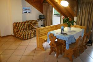 a living room with a table and chairs and a couch at Hotel Orsa Maggiore in Falcade