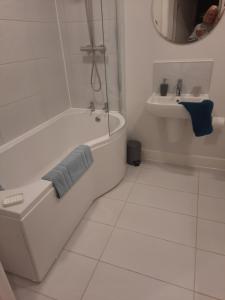 Baño blanco con bañera y lavamanos en Oystercatcher number 6 , 2 bedrooms maidencombe village, en Torquay