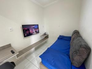 Schlafzimmer mit einem Bett und einem Flachbild-TV in der Unterkunft Studio Mobiliado 52 proximo a praia da Enseada in Guarujá