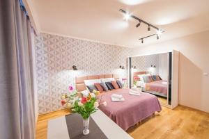 ein Schlafzimmer mit 2 Betten und einer Vase aus Blumen in der Unterkunft Cracowapart Ignacio A in Krakau