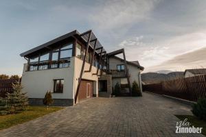 Casa blanca grande con entrada de ladrillo en Vila Zinnober, en Brasov