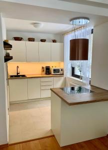 a kitchen with white cabinets and a counter top at Spacious house at the gate of Giant Mountains in Víchová nad Jizerou